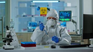 Science technician in ppe suit using micropipette and petri dish working in research laboratory analysing blood sample. Team examining virus evolution for vaccine development against covid19 video