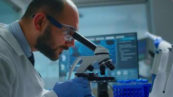 Lab technician examining samples and liquid using microscope in equipped laboratory. Scientist working with various bacteria, tissue and blood samples, pharmaceutical research for antibiotics video
