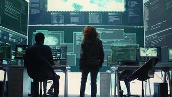 Governmental hackers team securing computer systems from cyber threats, working together in agency control room. Emphasizing encryption, online security and espionage against cyber attacks. Camera B. video