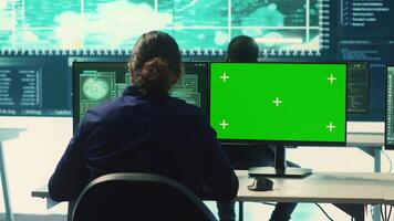 Hacking specialist works with an isolated chroma key display in high tech agency office, securing national servers with state secrets. Governmental hacker examines threat detection measures. Camera A. video
