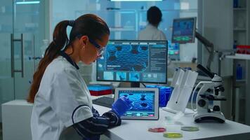 Lab technician doctor analyzing virus evolution looking on digital tablet. Team of scientists conducting vaccine development using high tech for researching treatment against covid19 pandemic. video