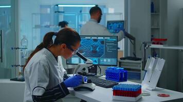 Medical research scientist conducting DNA experiments under microscope in equipped laboratory. Team chemist doctors examining virus evolution using high tech for vaccine development against covid19 video
