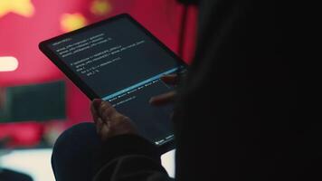 Chinese hacker uses a tablet in governmental cyber operations office to work on hybrid warfare and political manipulation. Inflicting manipulation and propaganda for the communism ideology. Camera A. video