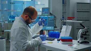 Scientist putting blood sample from test tube with micropipette in petri dish analysing chemical reaction. Lab technician examining virus evolution using high tech and tools for vaccine development video