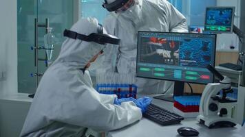 Fachmann Apotheke im ppe passen Analysieren Impfstoff Entwicklung zeigen auf pc Anzeige im ausgestattet Labor. Wissenschaftler Prüfung Virus Evolution mit hoch Technik recherchieren Diagnose gegen covid19 video