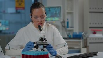 Microbiologist working with microscopic tool to research substance in laboratory. Chemistry engineer using microscope with optical lens and magnifying glass for scientific experiment in lab. video