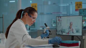 Scientist talking to expert on call conference in laboratory, using telecommunication on videoconference for development. Engineer meeting with woman on online remote teleconference video