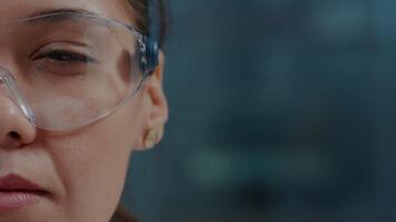 Microbiologist using protective glasses with virtual reality in laboratory. Woman chemist wearing goggles with 3d simulation vision to do scientific research for development. Close up video