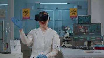 Woman biologist using vr glasses in science laboratory to work on scientific expertise and development. Specialist working with virtual reality goggles to do research with 3d projection in lab. video
