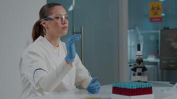 Woman chemist wearing virtual reality goggles in science laboratory, using 3d simulation to develop experiment. Specialist working with vr glasses and futuristic projection for development. video