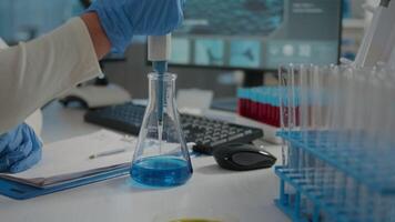 Chemical engineer using micro pipette to put solution in beaker, doing laboratory work for science development. Chemist working with lab equipment and glassware for research experiment. video