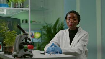 Pov of chemist scientific woman talking about biotechnology healthcare during online videocall meeting while sitting in biological lab. Specialists researching genetic mutation developing dna test video