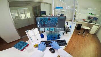 laboratório médico segurando teste tubo com azul amostra, escrevendo em computador enquanto colega de trabalho usando digital computador com toque Varredura. mulher examinando vírus evolução usando Alto tecnologia e química Ferramentas video