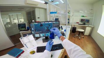 POV of medical scientist working with DNA scan image in modern equipped lab holding test tube with sample. Team examining vaccine evolution using high tech and chemistry tools for vaccine development video