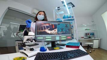 Team of microbiology scientists discussing about virus development in equipped laboratory using computer analysing test blood samples and develop vaccine, drugs and antibiotics against covid-19. video