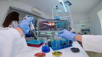 FPV of scientist using micropipette for filling test tube with liquid, conducting chemical experiment working in pharmaceutical lab with medicine, biotechnology researchers, developing vaccine video
