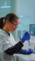 Vertical . Scientist in modern equipped medical laboratory examinining drug discovery with micropipette. Medical stuff examining vaccine evolution using high tech and technology researching treatment, development against covid19 video