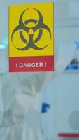 Vertical . Team of chemist doctors wearing protection suit working in danger area of medical research laboratory. Scientist examining vaccine evolution using high tech for research in treatment for covid19 virus video