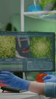 Vertical . Researcher woman measuring eco sapling while observing biological transformation. Scientist biologist examining genetic mutation on plants, working in biotechnology laboratory video