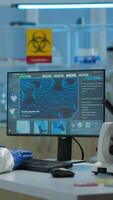 Vertical . Man scientist working at vaccine development typing on pc in coverall in modern laboratory. Team examining virus evolution in medical lab using high tech, chemistry tools for scientific research. video