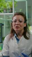 Vertical . Pov of chemist woman in white coat analyzing with biologists team during online videocall meeting while sitting in microbiology lab. Specialist researching genetic mutation developing dna test video