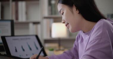 Footage of young Asian woman, freelance data scientist work remotely at home coding programming on Big data mining, AI data engineering, Female writes notes on tablet. IT Technician. Telework concept. video