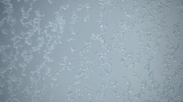 Wet snow falls on the glass melts and flows a drop down on a window at Christmas time. Cold wet weather on window pane. video