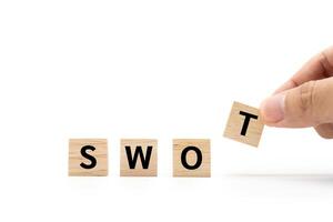 Hand place wooden blocks with SWOT text isolated on white background. SWOT analysis for Business concept. Copy space. photo