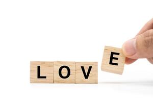 Hand place wooden blocks with LOVE text isolated on white background. Love symbol with copy space and clipping path. photo