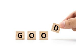 Hand place wooden blocks with GOOD text isolated on white background. Business and Good concept. Copy space. photo
