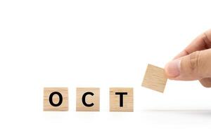 Hand place wooden blocks with OCT text isolated on white background. October and Calendar concept. Copy space. photo