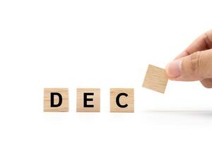 Hand place wooden blocks with DEC text isolated on white background. December and Calendar concept. Copy space. photo