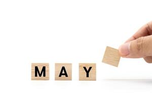 Hand place wooden blocks with MAY text isolated on white background. May and Calendar concept. Copy space. photo