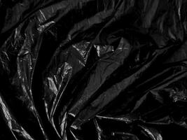 Transparent plastic wrap on the black background. Clean blank texture overlay effect template. Isolated wrinkle surface branding mock-up. photo