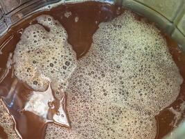 Close-up of craft beer and foam in a fermentation container. photo
