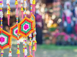 Crafting colorful yarn to use decorations for festivals. Decorative Mobile Spider web weaving hanging on a tree. Space for text photo