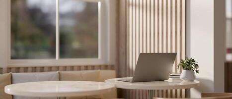 A back view image of a laptop computer on a table in a modern, comfortable cafe seating area. photo