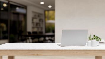 A back view image of a laptop computer and decorative plants on a white tabletop in a modern office. photo