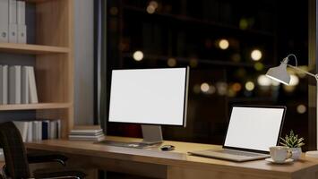 A contemporary luxurious private office at night features a computer and a laptop mockup on a table. photo