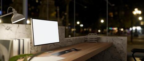 A computer with a white-screen mockup on a lobby reception counter at night. photo