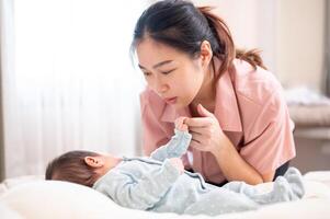 un recién nacido bebé participación su de mamá dedo. un mamá poniendo su infantil bebé a dormir en el dormitorio. foto