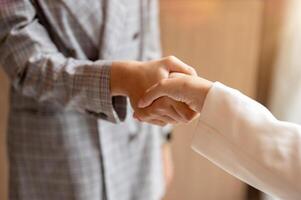 A close-up image of a businesswoman is shaking hands with her colleague in the meeting. teamwork photo