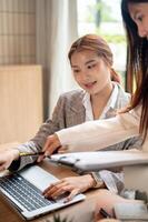 An Asian businesswoman is having a meeting with her colleague, discussing, planning their project. photo