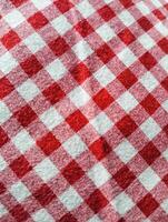 Red and white checkered tablecloth. Top view table cloth texture background. Red gingham pattern fabric. Picnic blanket texture. Red table cloth for Italian food menu. Square pattern. photo