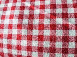 Red and white checkered tablecloth. Top view table cloth texture background. Red gingham pattern fabric. Picnic blanket texture. Red table cloth for Italian food menu. Square pattern. photo