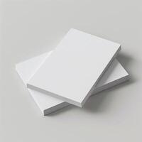 Two blank white books stacked on a light gray background, perfect for mockups, design presentations, or templates. photo