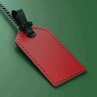 Red leather luggage tag with green stitching on a green background, perfect for travel accessories and identification purposes. photo