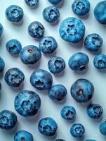 Fresh blueberries scattered on a white surface, showcasing their rich blue color and nutritious appeal, perfect for healthy eating concepts. photo