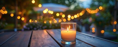 Warm and cozy outdoor evening scene with a lit candle on a wooden table, surrounded by glowing string lights, creating a serene and intimate atmosphere. photo
