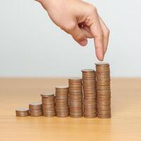 Money Saving for Future Plan, Retirement fund, Pension, Investment, Wealth, Salary and Financial concepts. hand step up coin on table, Money Counting and stack arrangement for Growth photo